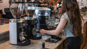 Mahlköng Grind-by-Sync grinders on cafe bar with barista