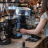 Mahlköng Grind-by-Sync grinders on cafe bar with barista